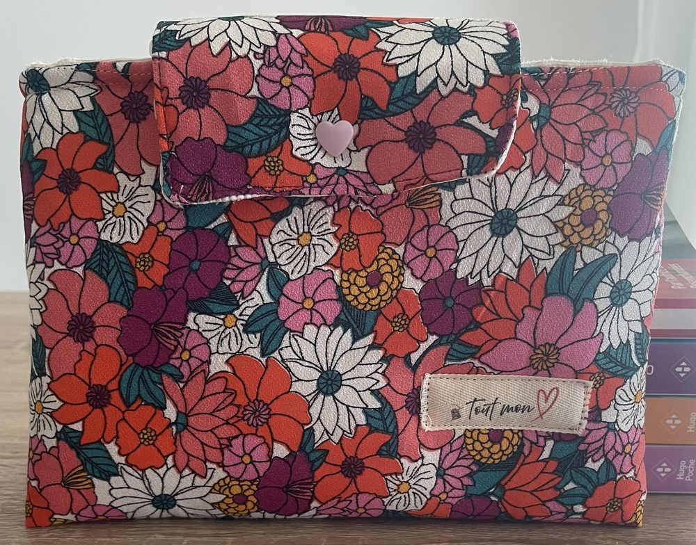 Pochette à livre en tissu fleuri coloré à grandes fleurs rouges, roses, blanches et violettes, avec rabat assorti et bouton cœur rose